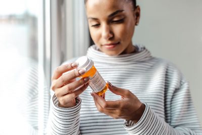 Woman with prescription bottle Getty Images 1450420379