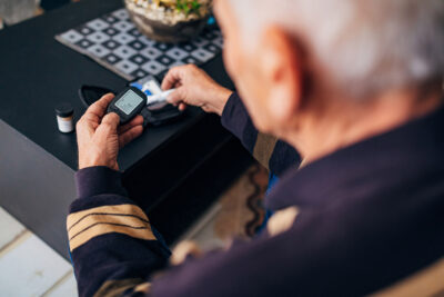 Older adult checking glucose Getty Images 1283538411