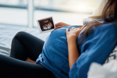 Pregnant woman looking at ultrasound Getty Images 1190394878