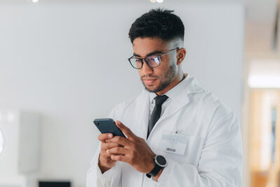 Male physician messaging on phone Getty Images 1429038051