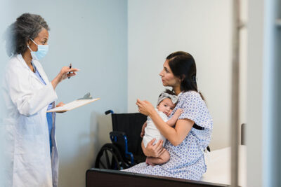 Mom and young infant with doctor Getty Images 1361756889