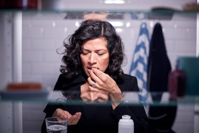 Woman in bathroom taking medication Getty Images 1207240310